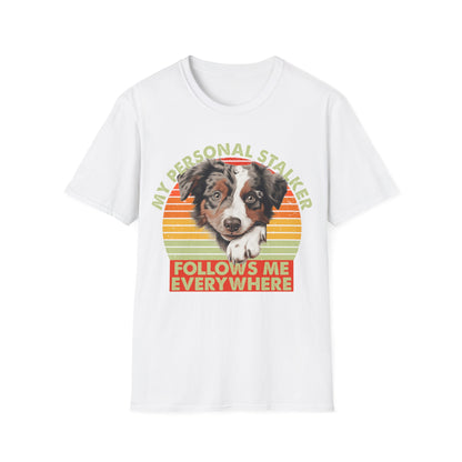 White unisex t-shirt Australian Shepherd with retro sunset and text that says 'My Personal Stalker Follows Me Everywhere', ideal for Aussie owners and dog lovers with Velcro dogs