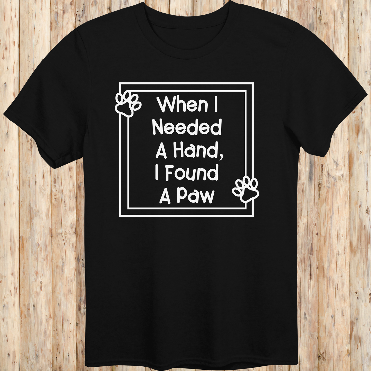 Black unisex t-shirt with text that reads 'When I Needed a Hand I Found a Paw', ideal for dog lovers and rescue pet adopters