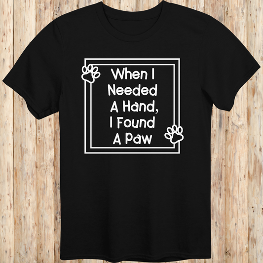 Black unisex t-shirt with text that reads 'When I Needed a Hand I Found a Paw', ideal for dog lovers and rescue pet adopters
