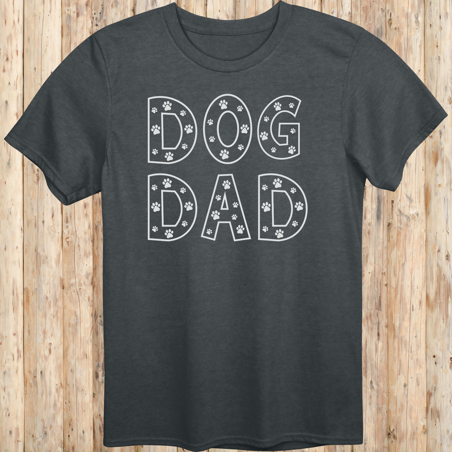 Dark heather unisex t-shirt with the words 'Dog Dad' in white text and small paw print accents, perfect for dog dads and pet owners