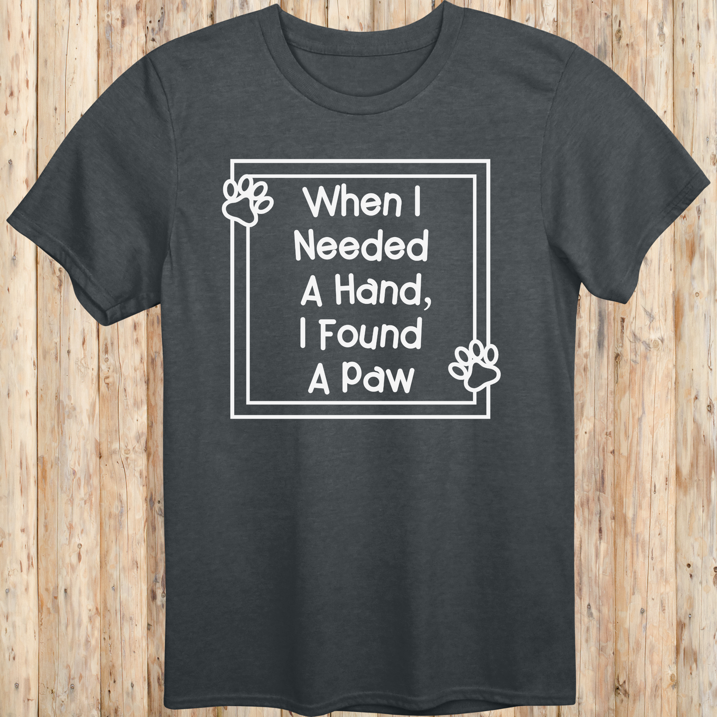 Dark heather unisex t-shirt with text that reads 'When I Needed a Hand I Found a Paw', ideal for dog lovers and rescue pet adopters