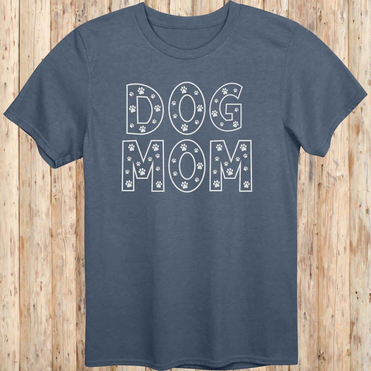 Heather indigo unisex t-shirt with the words 'Dog Mom' in white text and small paw print accents, ideal for pet moms and dog lovers