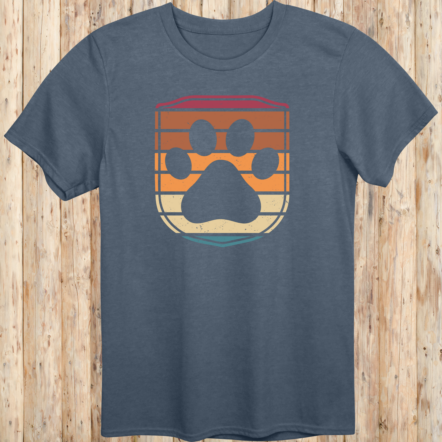Unisex heather indigo t-shirt featuring a retro-style dog paw print inside a colorful shield graphic, designed for dog lovers
