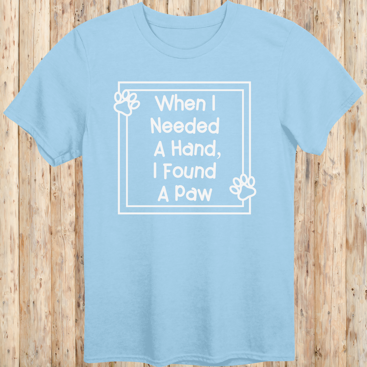 Light blue unisex t-shirt with text that reads 'When I Needed a Hand I Found a Paw', ideal for dog lovers and rescue pet adopters