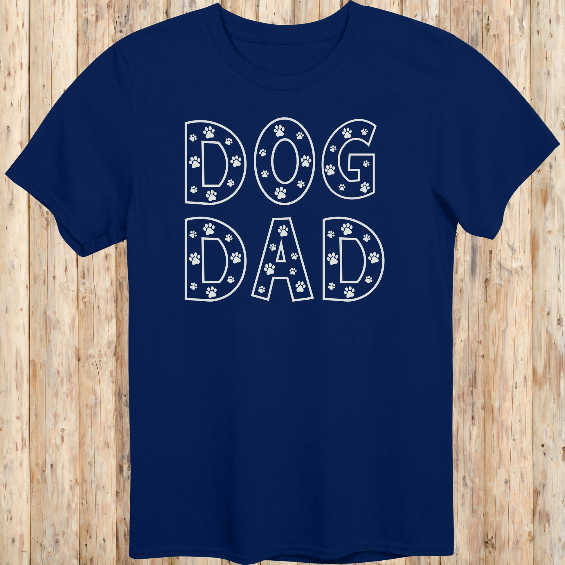 Navy blue unisex t-shirt with the words 'Dog Dad' in white text and small paw print accents, perfect for dog dads and pet owners