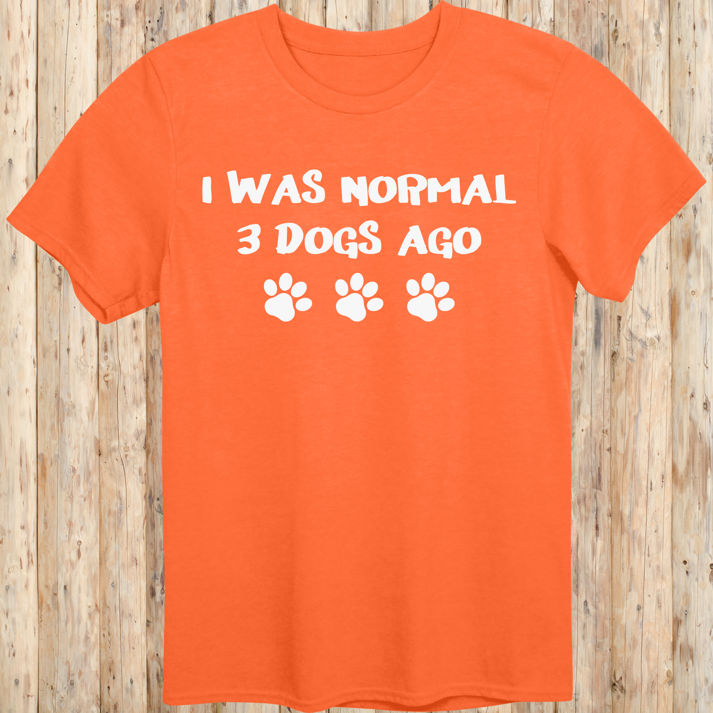 Orange unisex t-shirt with text that says 'I Was Normal 3 Dogs Ago', ideal for dog lovers and multiple pet owners