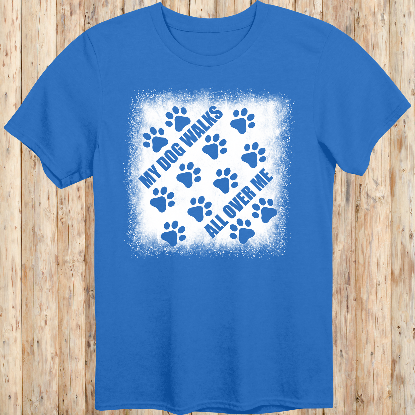 Royal blue unisex t-shirt with paw prints and the phrase 'My Dog Walks All Over Me' printed on the front for men women adults and humans.
