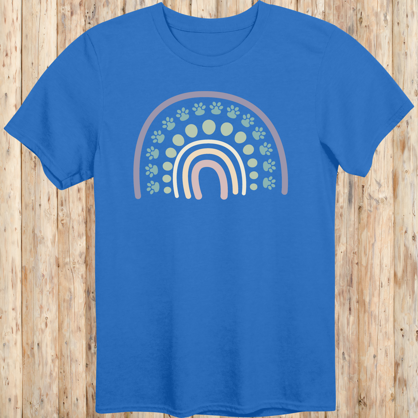 Royal blue unisex t-shirt with a colorful boho rainbow and white dog paw print design, ideal for dog lovers and pet parents with a boho style