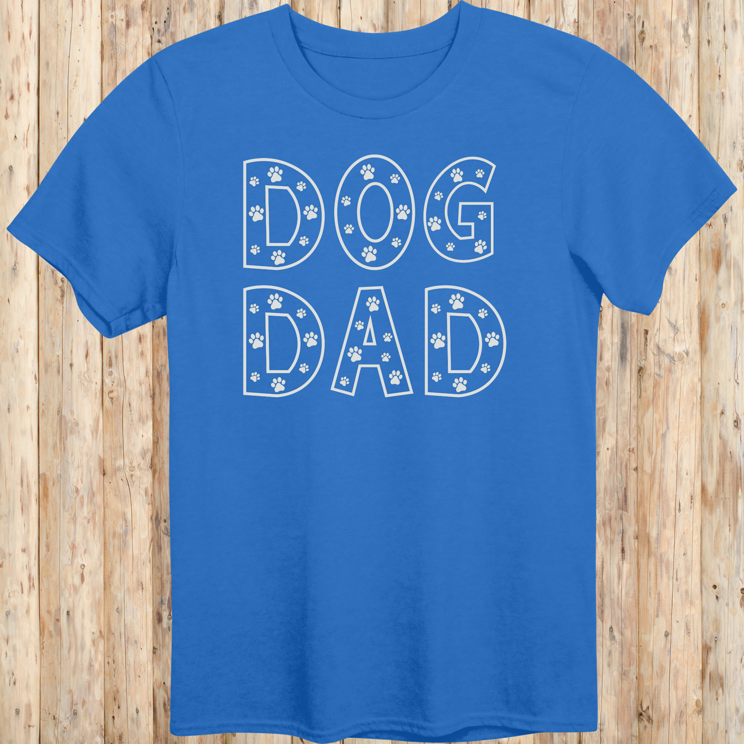 Royal blue unisex t-shirt with the words 'Dog Dad' in white text and small paw print accents, perfect for dog dads and pet owners
