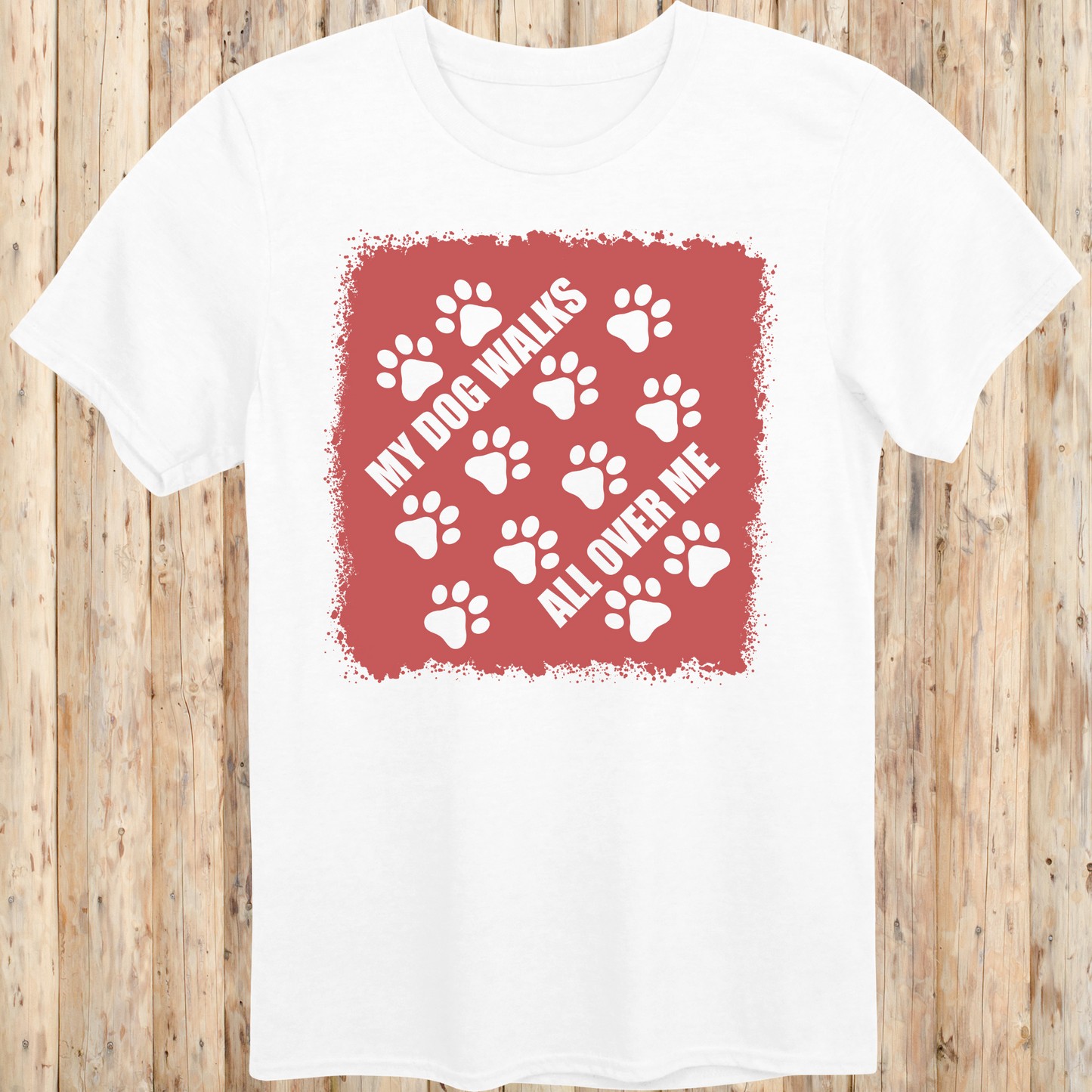 White unisex t-shirt with paw prints and the phrase 'My Dog Walks All Over Me' printed on the front for men women adults and humans.
