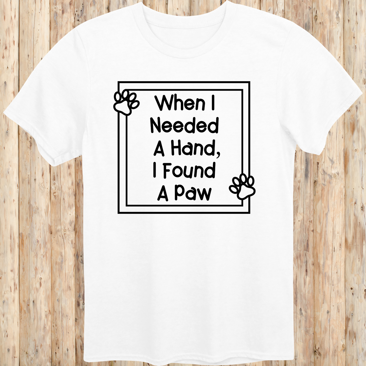 White unisex t-shirt with text that reads 'When I Needed a Hand I Found a Paw', ideal for dog lovers and rescue pet adopters
